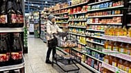 File - A woman checks prices as she shops at a grocery store in Wheeling, Ill., US. 19 January 2024.