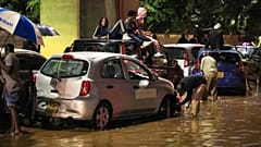 In Nairobi klettern Menschen am Freitag, dem sechsten März zweitausendsechsundzwanzig, nach heftigen Regenfällen auf ihre Autos, weil Straßen überflutet sind.
