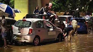 People climb on top of their cars after heavy rains flooded roads in Nairobi, Kenya, on Friday, March 6, 2026. 