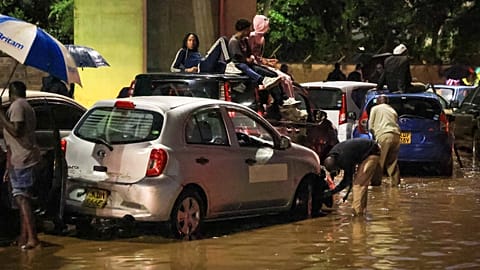 People climb on top of their cars after heavy rains flooded roads in Nairobi, Kenya, on Friday, March 6, 2026. 
