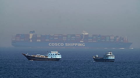 Two traditional dhows sail by a large container ship in the Strait of Hormuz, 19 May, 2023