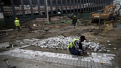 Строитель выравнивает тротуары в Лиссабоне в пятницу, 23 января 2015 года.