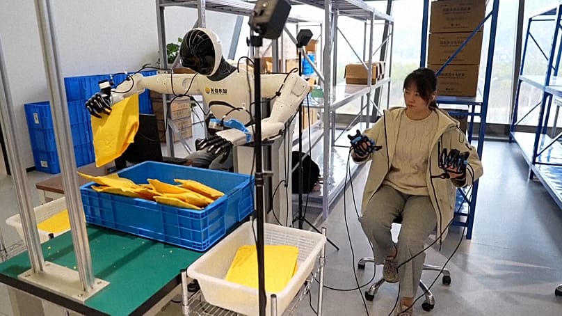 باحثة تُعلِّم روبوتا بشريا رفع الطرود وفرزها وترتيبها.