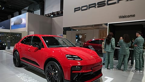 Presenters stand next to the Porsche Macan GTS prior to its European Premiere unveiling, Brussels, Belgium, Jan. 2026