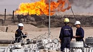 عمال عراقيون في مصفاة رومَيْلة للنفط بالقرب من مدينة البصرة، على بعد 550 كيلومترًا جنوب شرق بغداد، العراق.