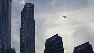 Un avión de Emirates Airlines vuela sobre rascacielos en el centro de Dubái, Emiratos Árabes Unidos, el 7 de marzo de 2026.