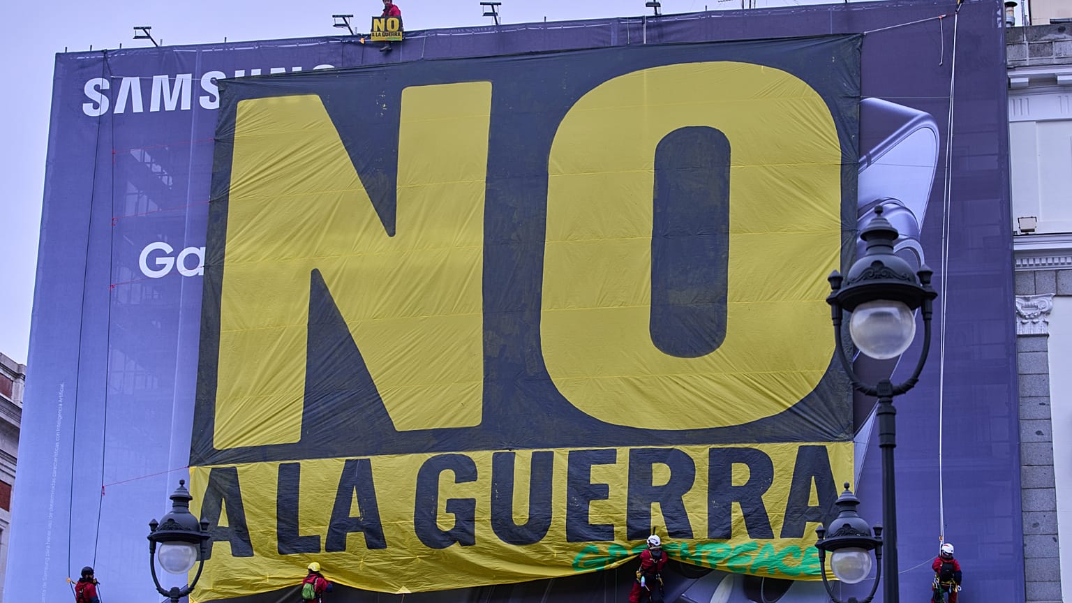 Activistas de Greenpeace cuelgan una pancarta con la leyenda "No a la guerra" en el centro de Madrid, el martes 10 de marzo de 2026.