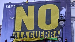 Activistas de Greenpeace cuelgan una pancarta con la leyenda "No a la guerra" en el centro de Madrid, el martes 10 de marzo de 2026.
