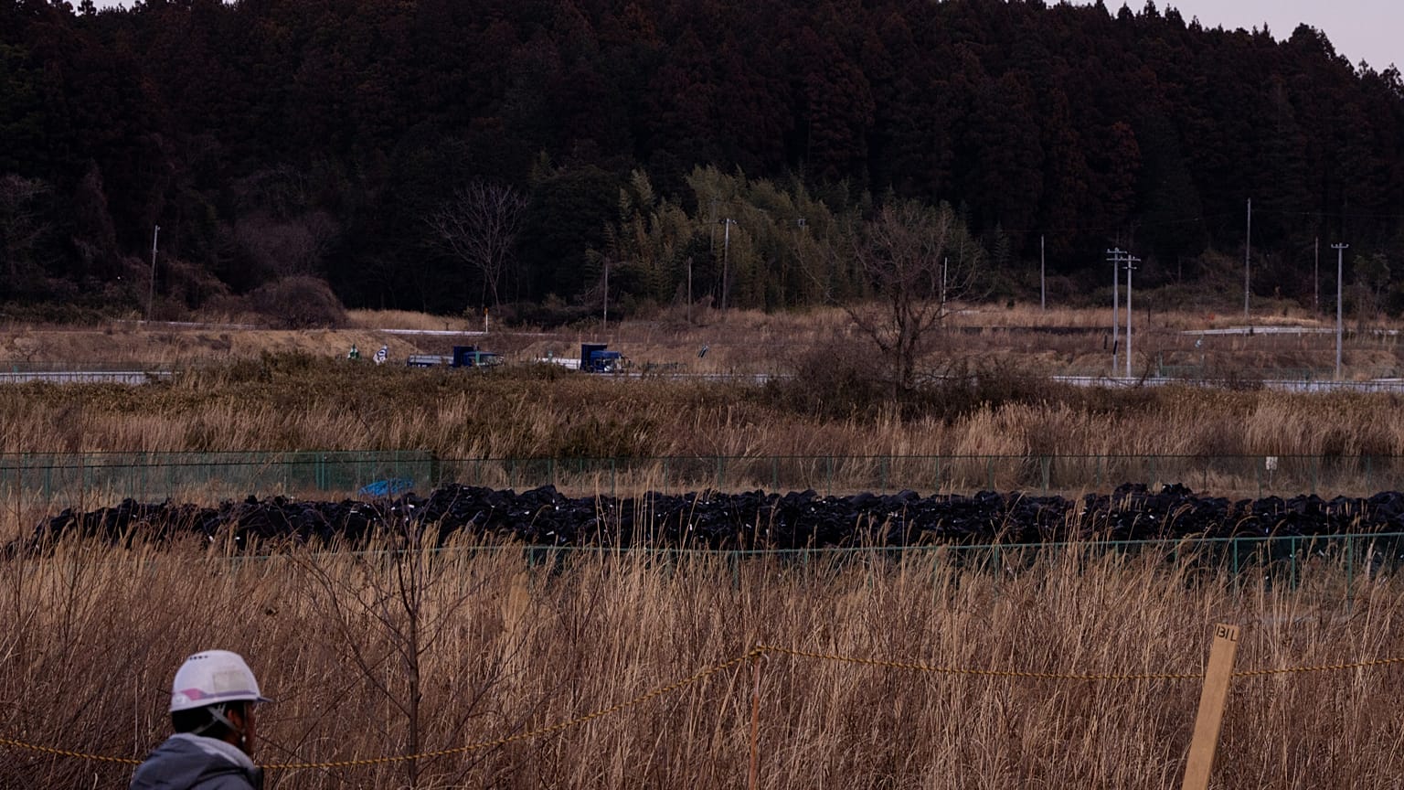Sacos pretos com terra removida durante trabalhos de descontaminação estão empilhados em Okuma, na província de Fukushima, esta sexta-feira