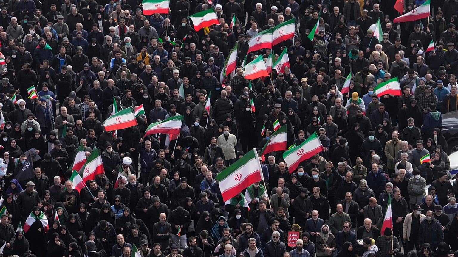 يحمل المشيعون الأعلام الإيرانية بينما يحضر حشد من الناس موكب جنازة كبار المسؤولين العسكريين الإيرانيين والمدنيين الذين قتلوا خلال الحملة الأمريكية الإسرائيلية في طهران، إيران،