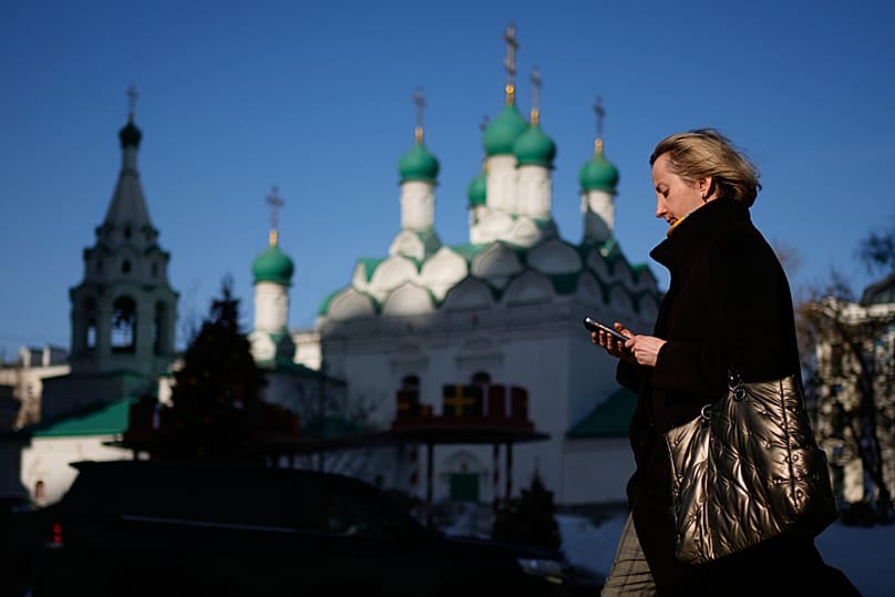 امرأة تتفقد هاتفها أثناء سيرها في أحد شوارع موسكو، الثلاثاء، 10 مارس 2026.