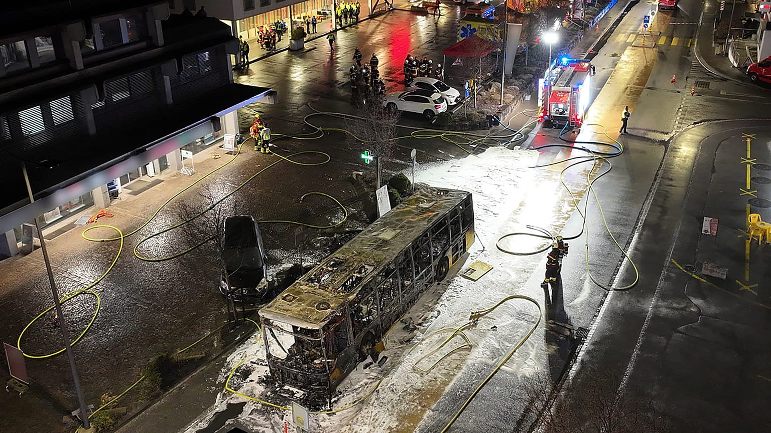 Les secours interviennent sur l'épave calcinée d'un bus après un incendie à Kerzers, en Suisse, mardi 10 mars 2026.