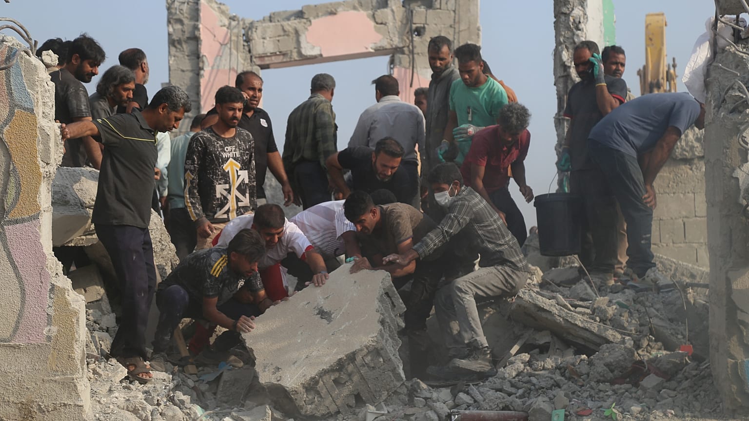 Rescue workers and residents search through the rubble in the aftermath of a strike on a girls' elementary school in Minab, Iran, Saturday, Feb. 28, 2026.