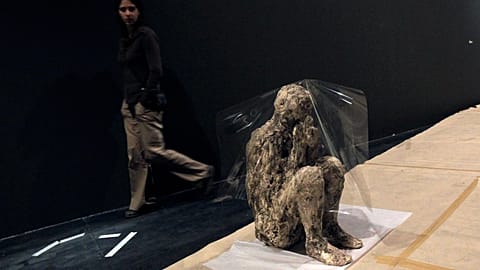 FILE: A conservator glances at a body of a victim who was frozen in its last moment when Mount Vesuvius in Italy erupted in 79 A.D