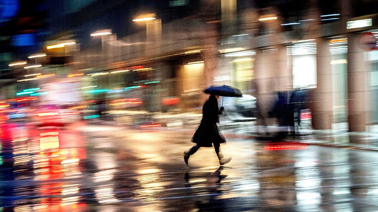 Ein Mann überquert an einem regnerischen und windigen Tag die Straße in Frankfurt, Deutschland, am Donnerstag, den 2. Januar 2025.