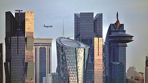 An aircraft flying near skyscrapers of West Bay, approaches the Hamad International Airport in Doha, Qatar, Thursday, Jan. 25, 2024.