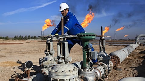 FILE. Iraqi worker operates valves in Nihran Bin Omar field, Iraq, Apr. 2017