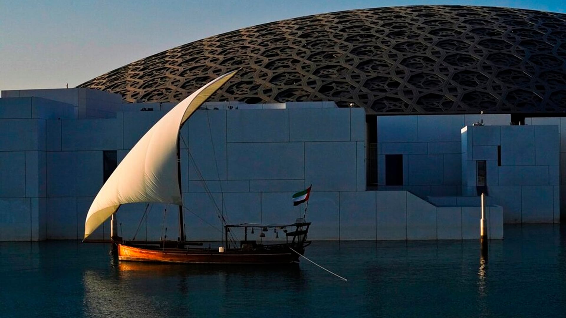 Un velero está anclado al atardecer frente al Louvre Abu Dhabi en Abu Dhabi, Emiratos Árabes Unidos, el jueves 16 de diciembre de 2021.