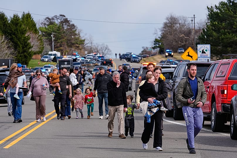 Law enforcement escort families with children away from the Temple Israel synagogue Thursday, March 12, 2026, in West Bloomfield Township, Michigan.