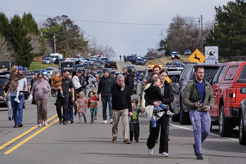Les forces de l'ordre escortent des familles avec enfants loin de la synagogue Temple Israel, jeudi 12 mars 2026, à West Bloomfield Township, dans le Michigan. 