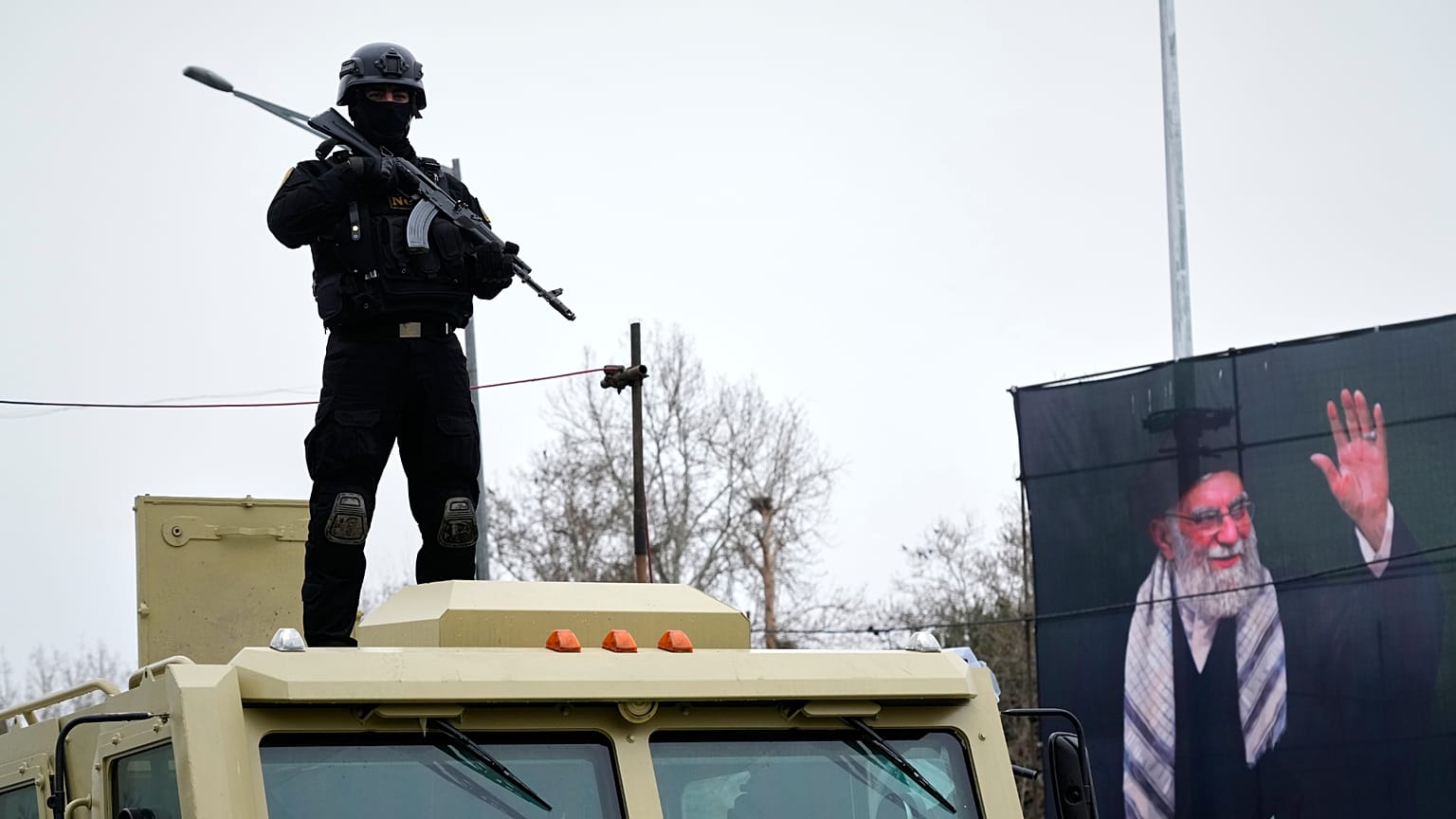 A policeman stands next to a portrait of the late Ayatollah Ali Khamenei during the annual anti-Israeli Quds Day, in Tehran, 13 March 2025