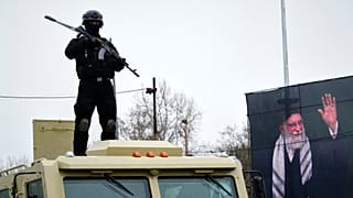 A policeman stands next to a portrait of the late Ayatollah Ali Khamenei during the annual anti-Israeli Quds Day, in Tehran, 13 March 2025