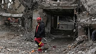 Ein Rettungsarbeiter durchsucht die Trümmer eines Wohnhauses in Teheran, Iran, Donnerstag, 12. März 2026, nachdem es am Sonntag während der US-israelischen Luftangriffe beschädigt wurde