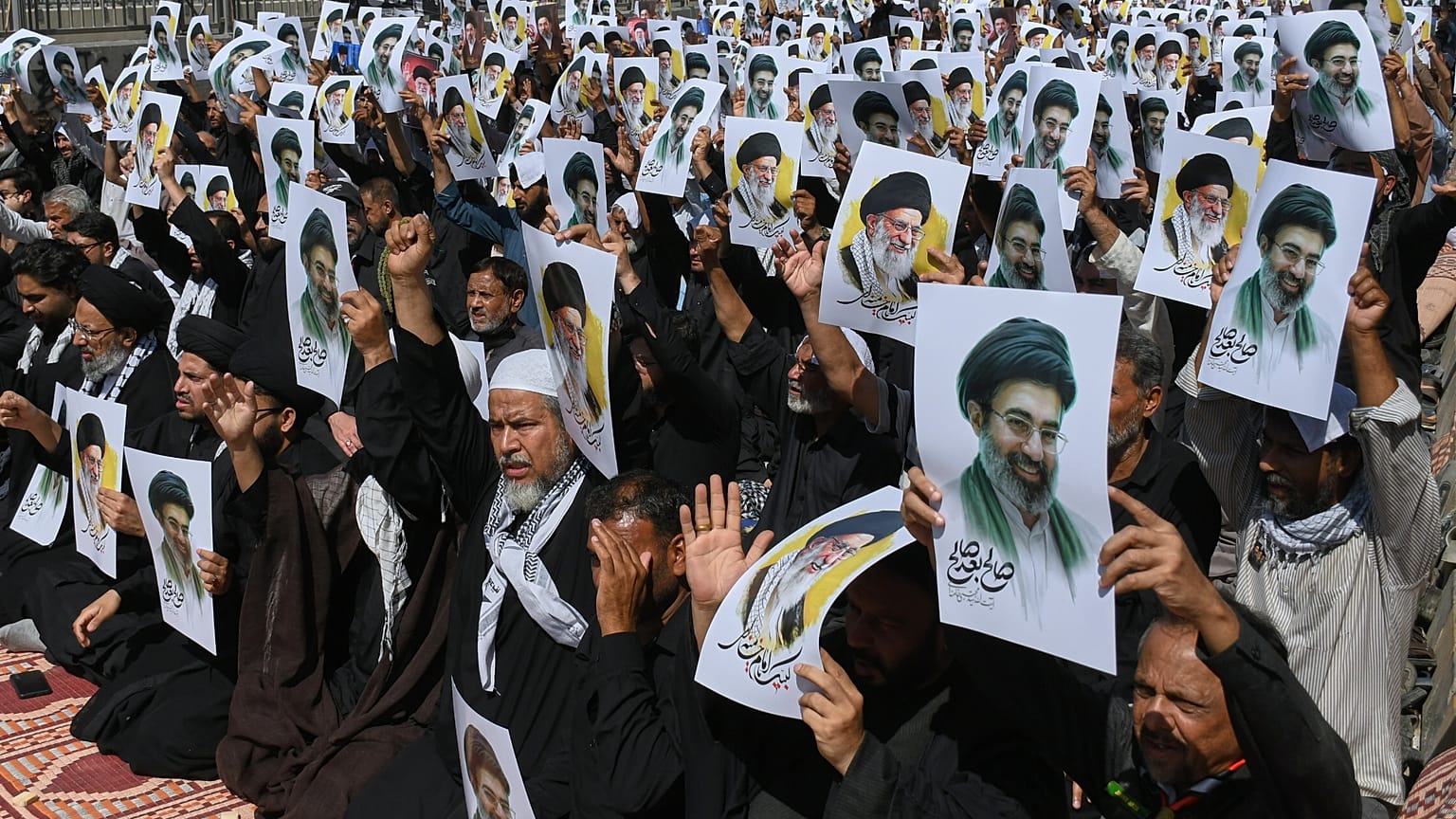 المسلمون الشيعة يحملون ملصقات تصور القادة الأعلى الإيرانيين آية الله مجتبى خامنئي ووالده الراحل آية الله علي خامنئي لإظهار دعمهم خلال موكب في كراتشي