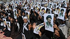 المسلمون الشيعة يحملون ملصقات تصور القادة الأعلى الإيرانيين آية الله مجتبى خامنئي ووالده الراحل آية الله علي خامنئي لإظهار دعمهم خلال موكب في كراتشي
