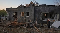 A woman looks at a house destroyed by an Iranian missile strike in Zarzir, northern Israel
