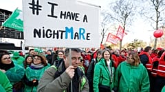 A protestor holds a sign as he demonstrates during general strike actions in Brussels, Thursday, March 12, 2026. (