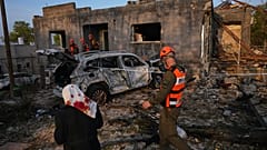 سكان وضباط من قيادة الجبهة الداخلية الإسرائيلية يتفقدون منزلاً دمرته غارة صاروخية إيرانية في زرزير، شمال إسرائيل