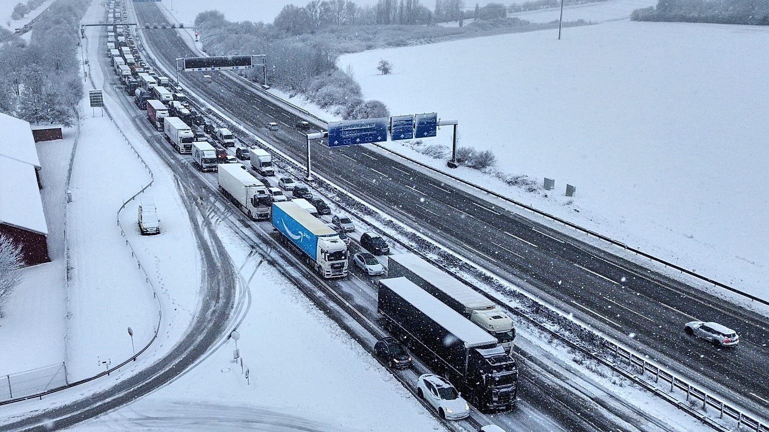 Autos und Lastwagen stehen nach starken Schneefällen in der Nacht auf einer Autobahn in Frankfurt am Main, Deutschland, am 19. Februar 2026, im Stau. 