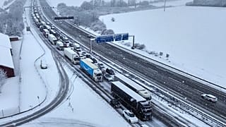 Autos und Lastwagen stehen nach starken Schneefällen in der Nacht auf einer Autobahn in Frankfurt am Main, Deutschland, am 19. Februar 2026, im Stau. 