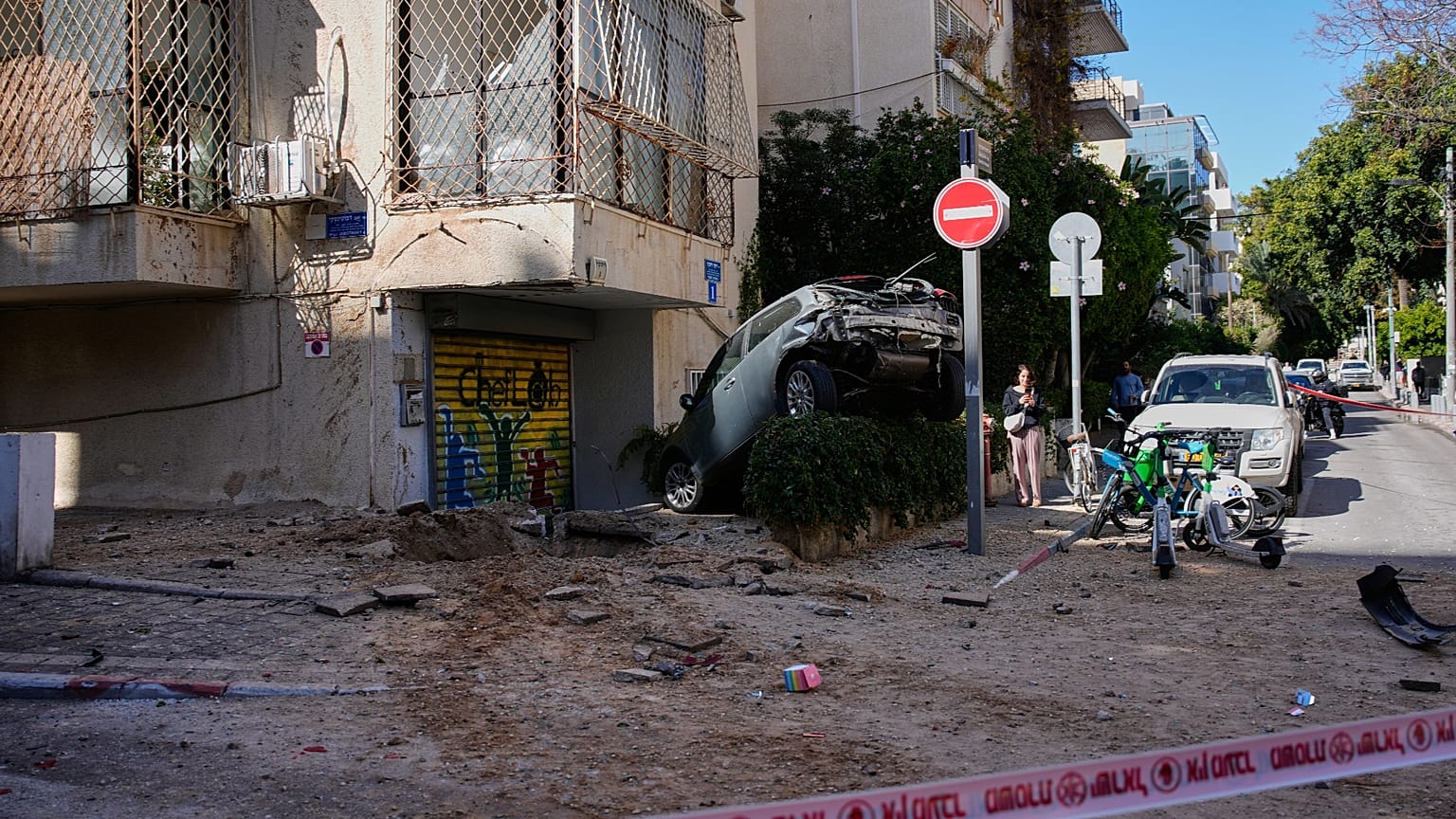 امرأة تمر بجوار منطقة مغلقة تضررت خلال غارة جوية في تل أبيب، إسرائيل، الأحد 8 مارس 2026. (صورة AP/أوهاد زويجنبرج)