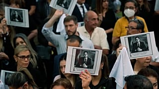 ARCHIVO - Varias personas portan imágenes del fallecido fiscal antidrogas Marcelo Pecci durante una protesta tras su asesinato en Asunción, Paraguay, el 13 de mayo de 2022.