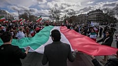 Members of the large Iranian diaspora in France hold an Iranian flag during a demonstration 