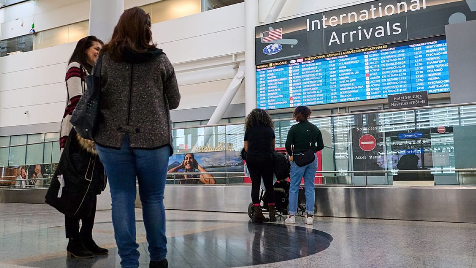 ينتظر الناس خروج المسافرين من أبواب الوصول الدولية في مطار بيرسون في تورنتو، يوم السبت 7 مارس 2026. 