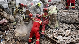 Tahran'da görevliler enkaz altından insanları kurtarmaya çalışıyor.