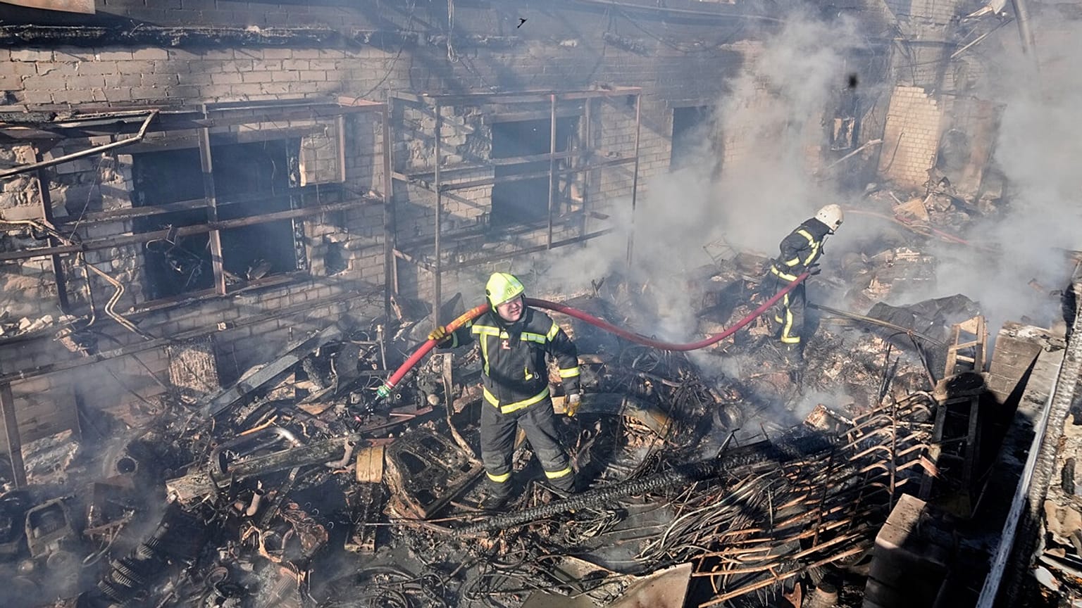 Firefighters put out the fire at a residential neighbourhood following a Russia missile and drone attack, in Brovary, close to Kyiv, Ukraine, Saturday, March 14, 2026. 