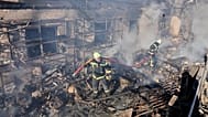 Firefighters put out the fire at a residential neighbourhood following a Russia missile and drone attack, in Brovary, close to Kyiv, Ukraine, Saturday, March 14, 2026. 