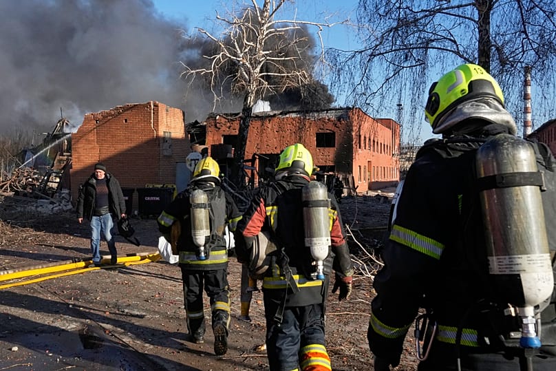 Firefighters approach the damaged railway workshops following a Russia missile and drone attack, in Brovary close to Kyiv, Ukraine, Saturday, March 14, 2026. 