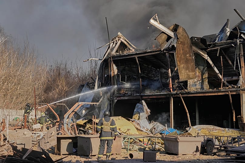 Firefighters put out the fire at railway workshops following a Russia missile and drone attack, in Brovary, close to Kyiv, Ukraine, Saturday, March 14, 2026.