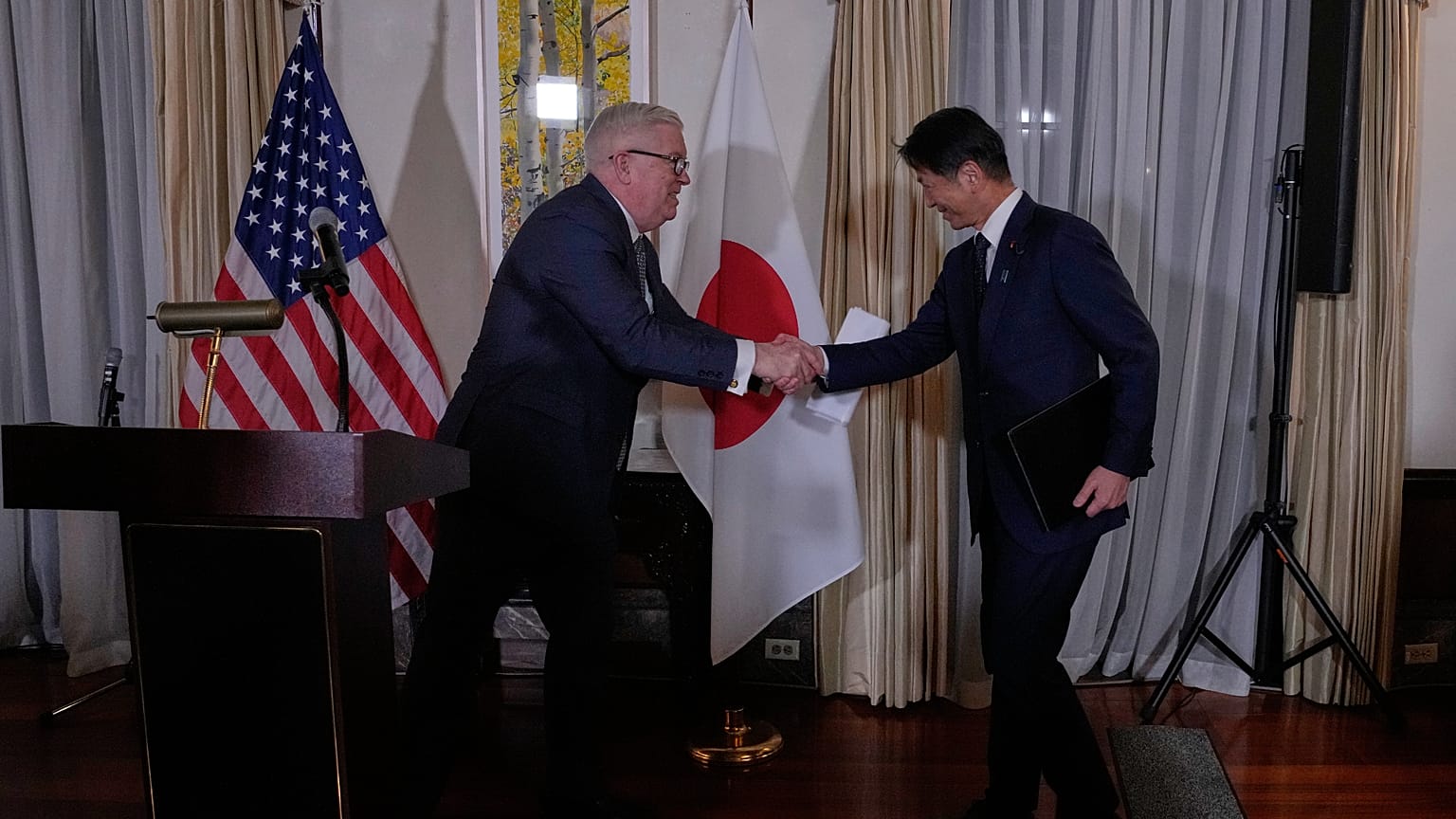 جورج غلاس، سفير الولايات المتحدة لدى اليابان، ونائب وزير الاقتصاد والتجارة والصناعة الياباني كينجي يامادا، يصافحان بعضهما خلال حفل استقبال المنتدى الوزاري والتجاري لأمن الطاقة