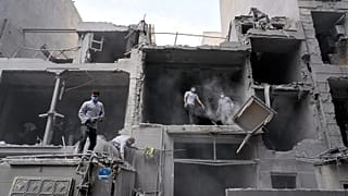 Volunteers clean debris from a residential building damaged when a nearby police station was hit in Tehran, 15 March, 2026