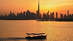 Ein Mann steuert ein Boot während des Sonnenuntergangs in Dubai, 11. März, 2026