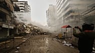 A man photographs the rubble of buildings destroyed in an Israeli airstrike in Dahiyeh, Beirut's southern suburbs, Lebanon, Sunday, March 15, 2026. 