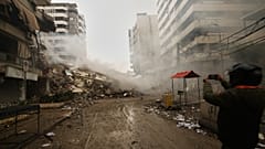 Um homem fotografa os escombros de edifícios destruídos por um ataque aéreo israelita em Dahiyeh, nos subúrbios do sul de Beirute, no Líbano, domingo, 15 de março de 2026. 