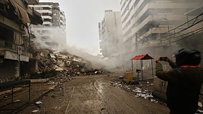 A man photographs the rubble of buildings destroyed in an Israeli airstrike in Dahiyeh, Beirut's southern suburbs, Lebanon, Sunday, March 15, 2026. 