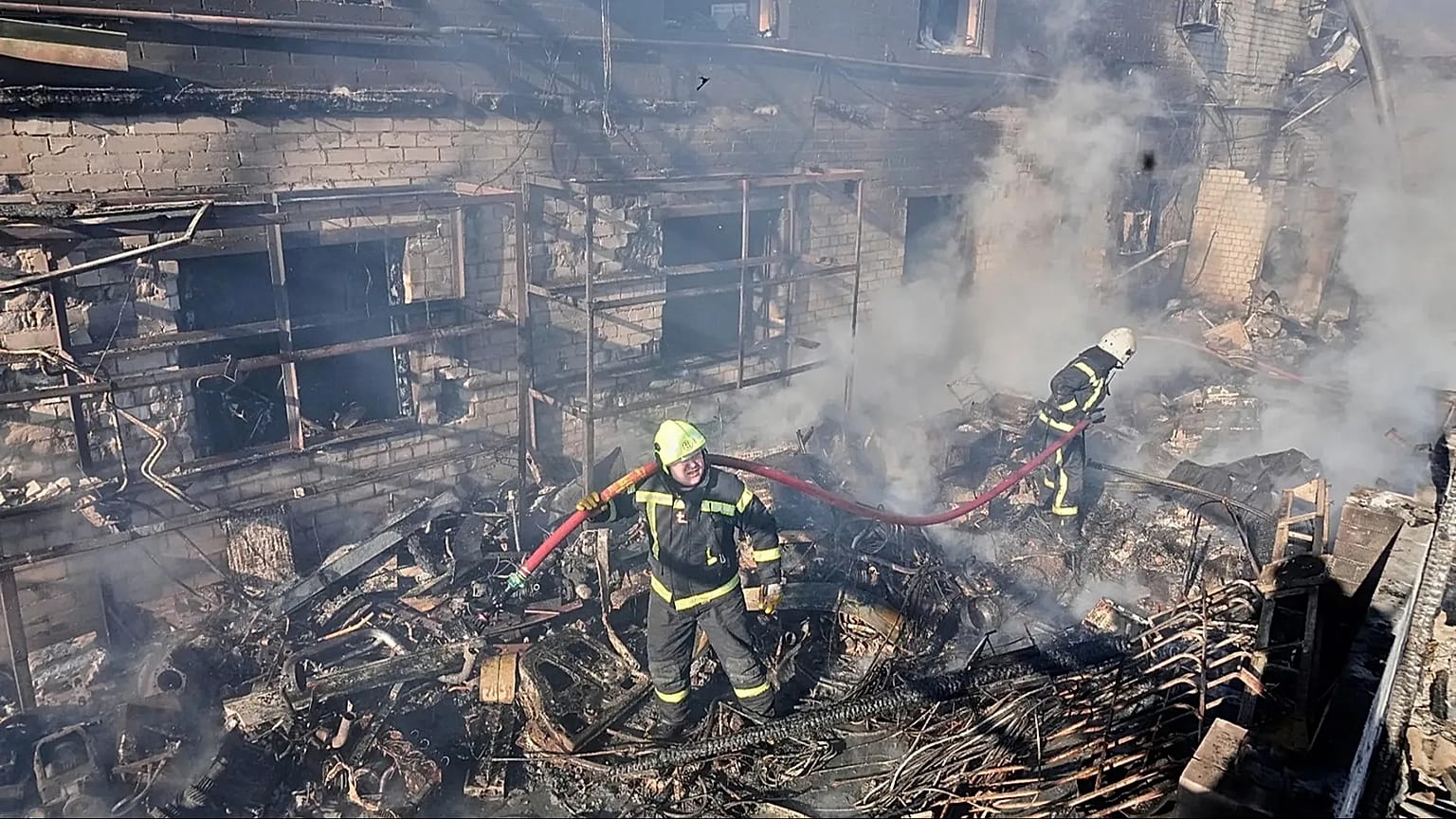 Firefighters put out the fire in a residential neighborhood following a Russian missile and drone attack, in Brovary, close to Kyiv, Ukraine, Saturday, March 14, 2026.